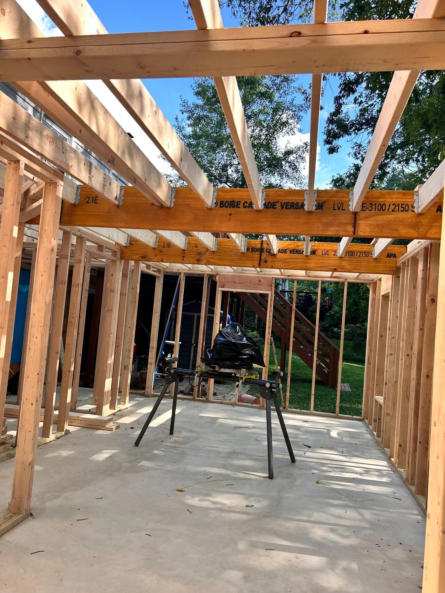 Interior view of a building under construction. Wooden framing forms walls and ceiling.
