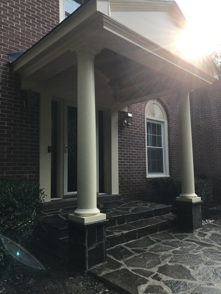 A brick house with a porch and stairs