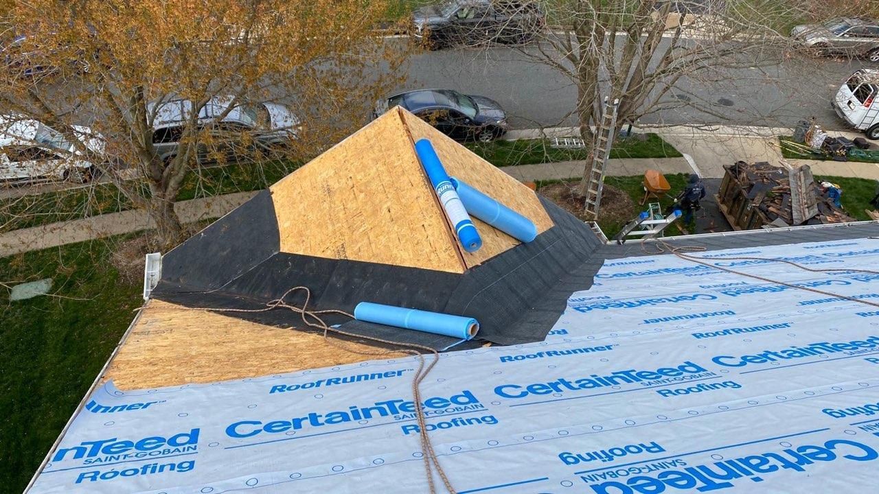 A pyramid shaped piece of wood is sitting on top of a roof.