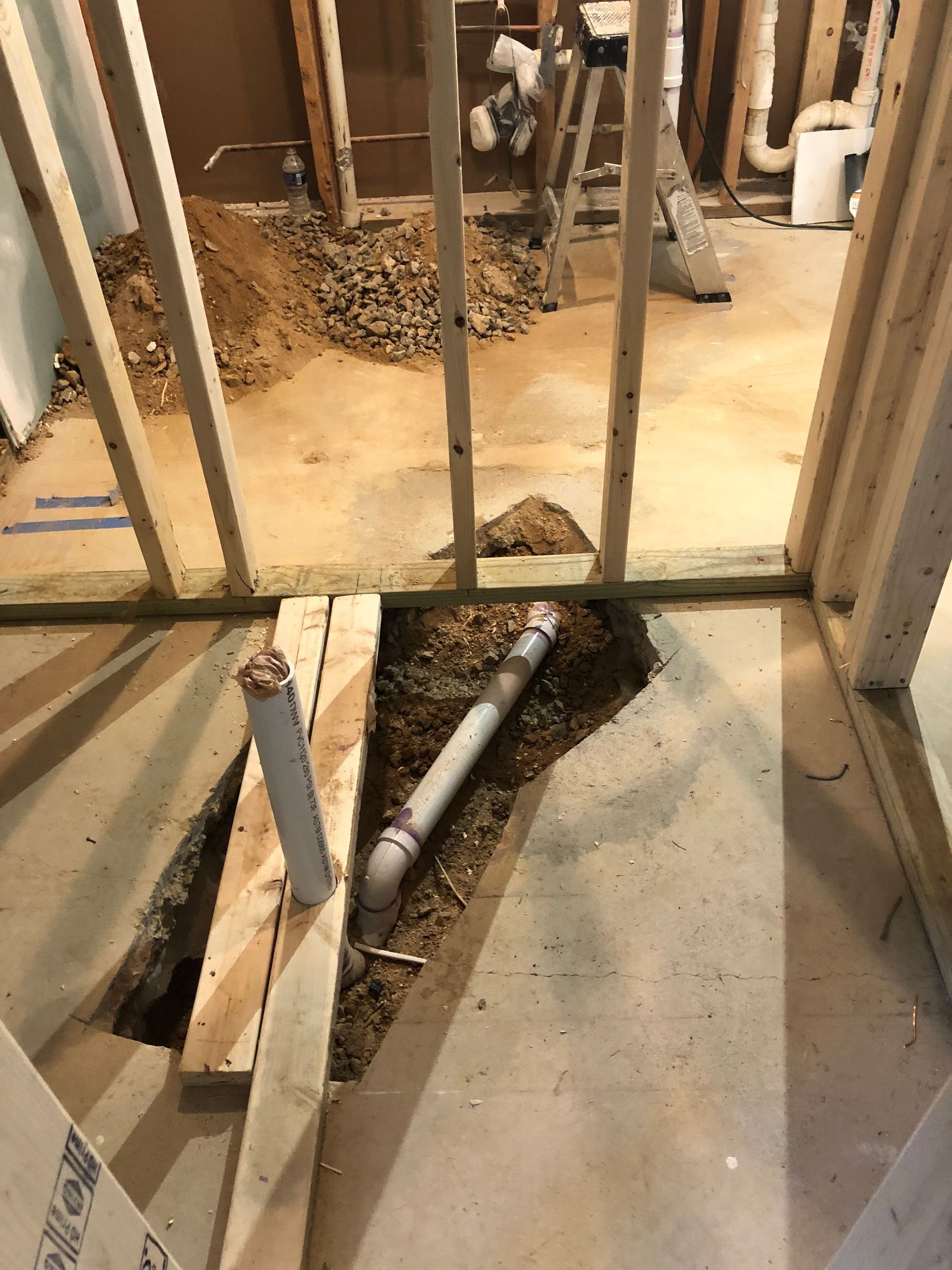 A bathroom under construction with a hole in the floor