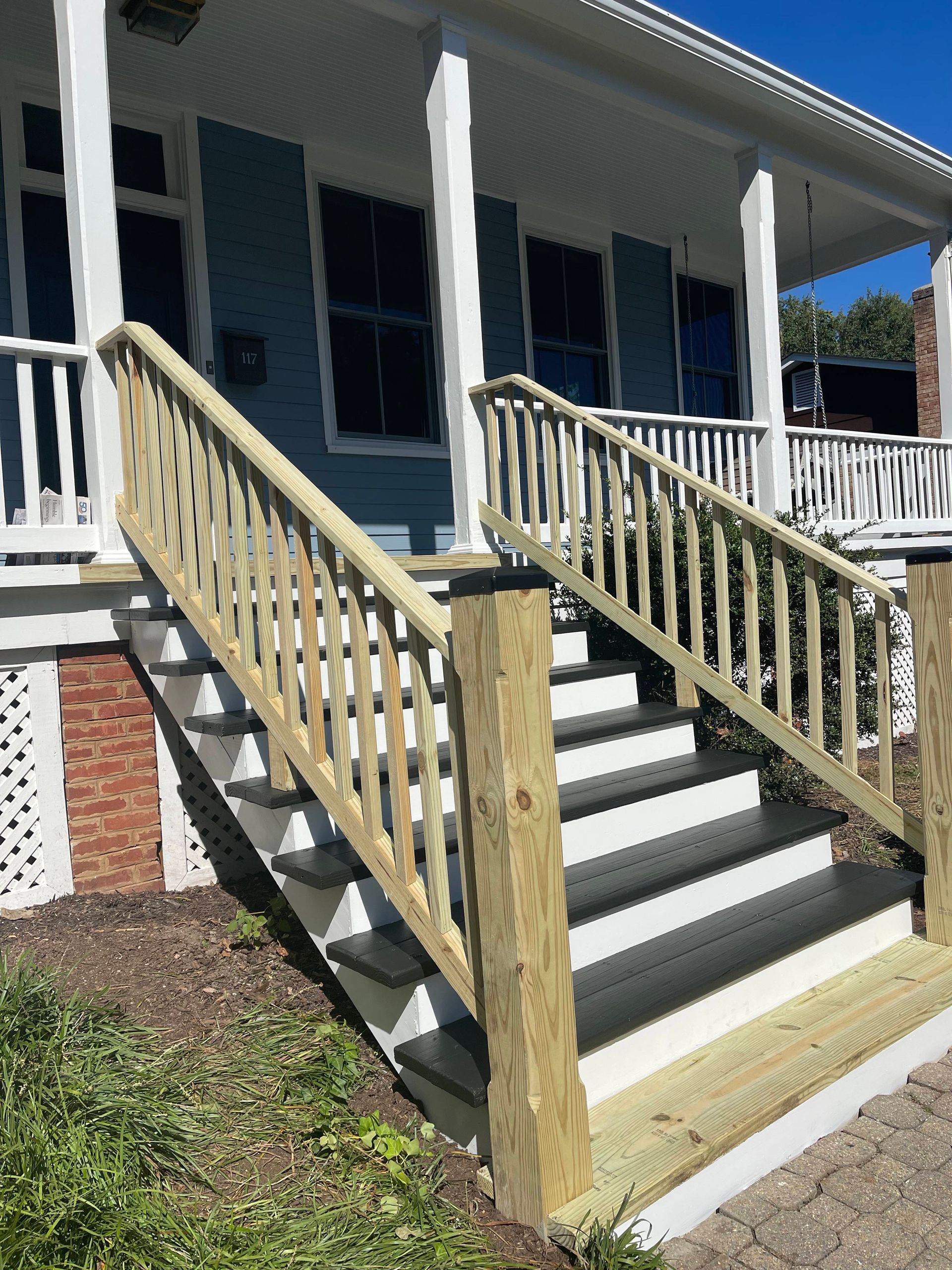 Front porch with wheelchair-accessible wooden ramp and railings leading to a house entrance