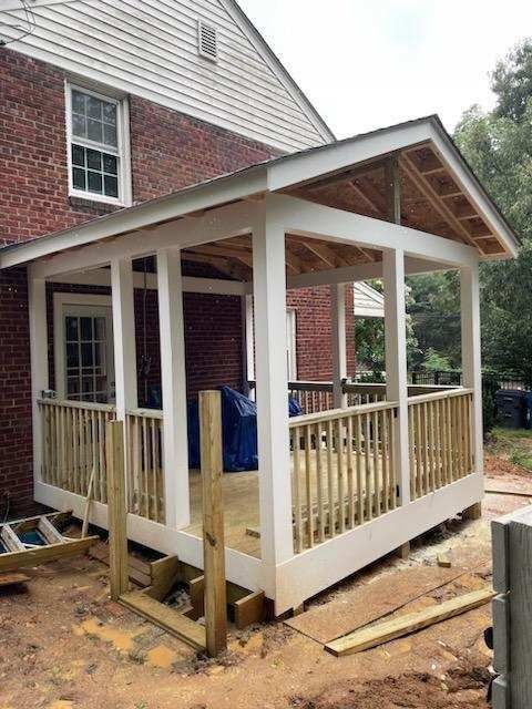 A porch is being built on the side of a brick house.