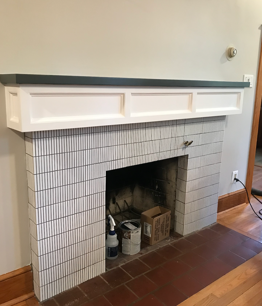 A fireplace with a white mantle in a living room.
