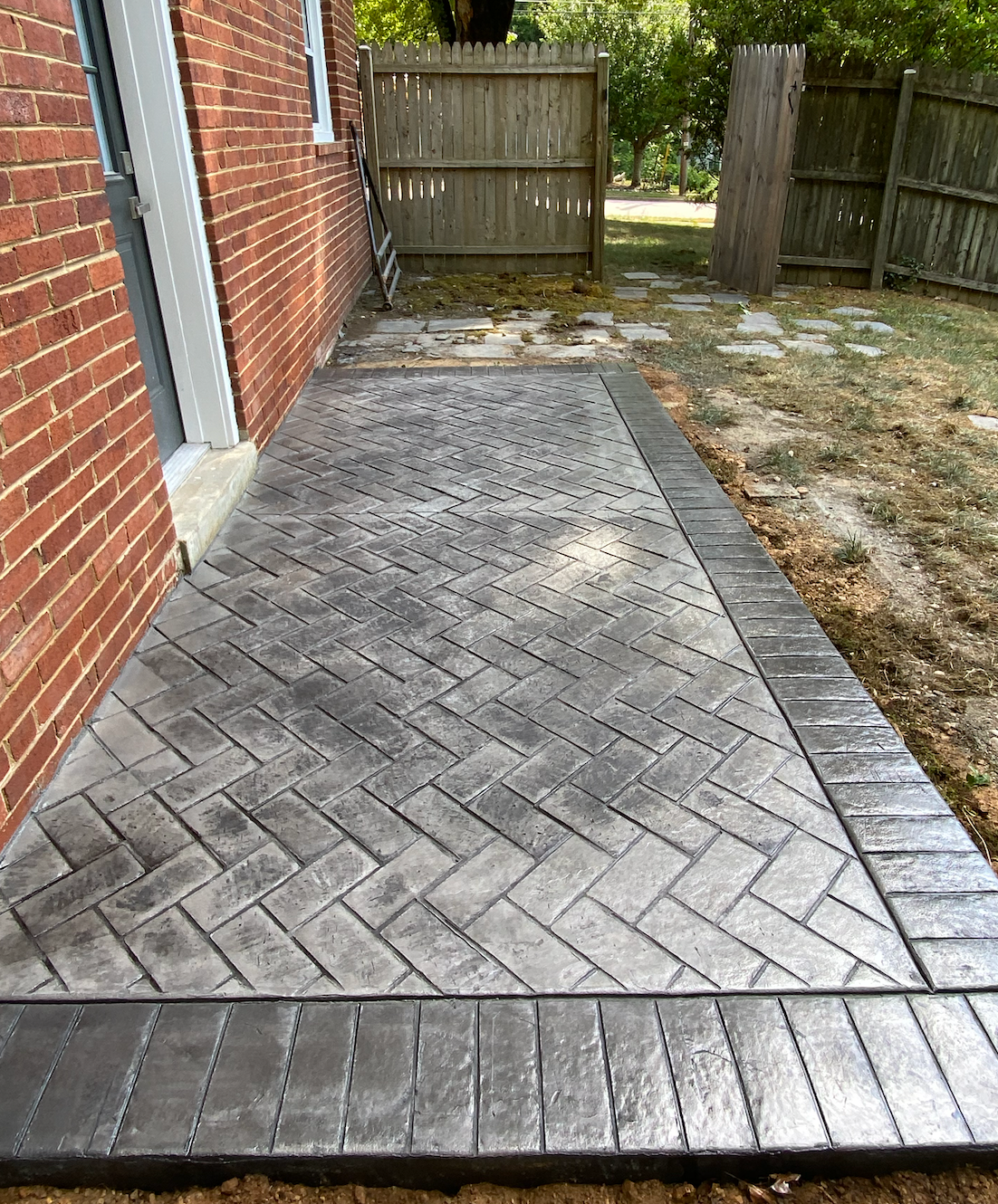 A brick building with a concrete walkway in front of it.