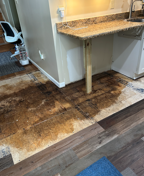 A kitchen with a wooden floor and a granite counter top.