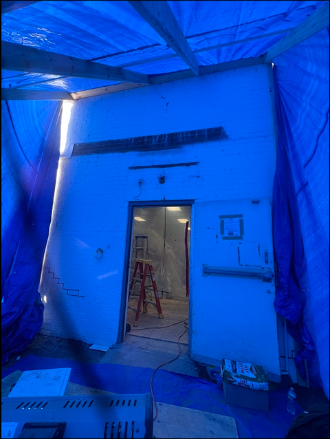A blue tarp is covering the inside of a building