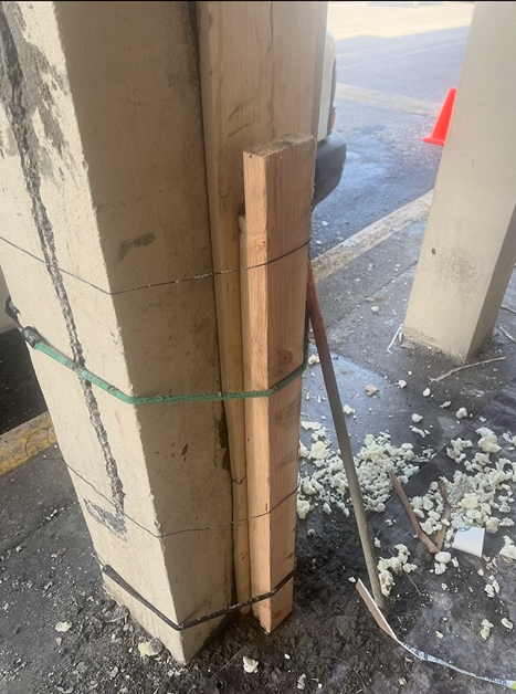 A piece of wood is tied to a concrete pole