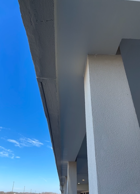 Looking up at the ceiling of a building with a blue sky in the background.