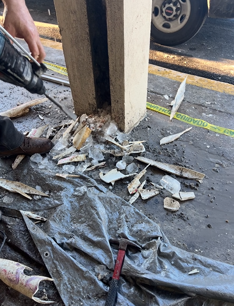 A person is using a drill to drill a hole in the ground.