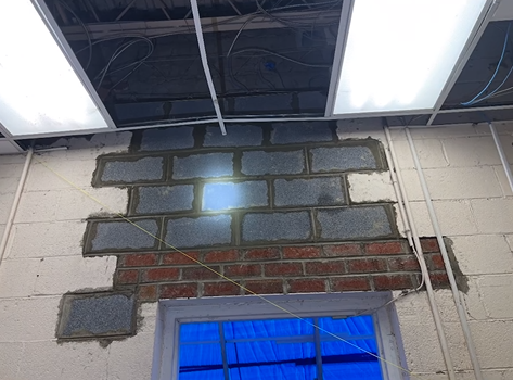 A brick wall with a window in the middle of it