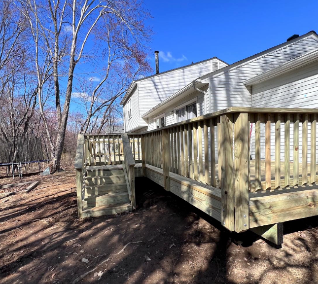 A white house with a wooden deck in front of it