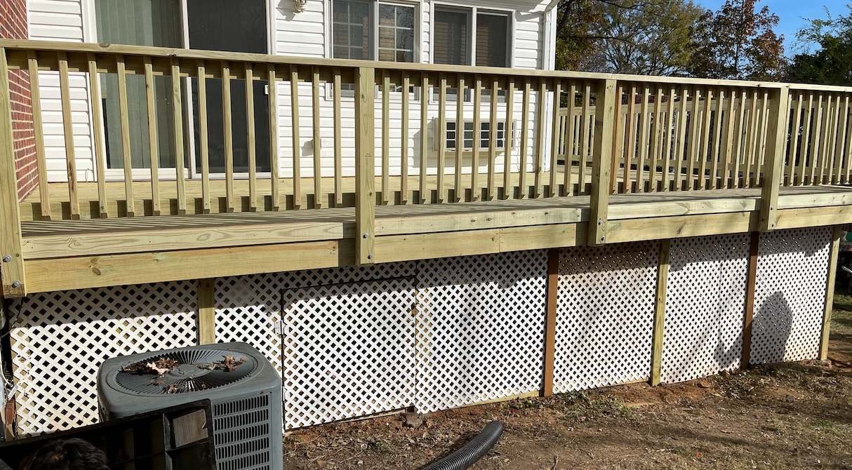A wooden deck is attached to the side of a house.
