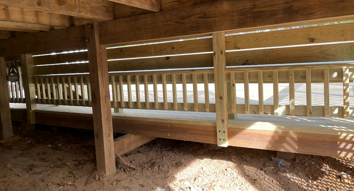 A wooden deck is being built under a house.