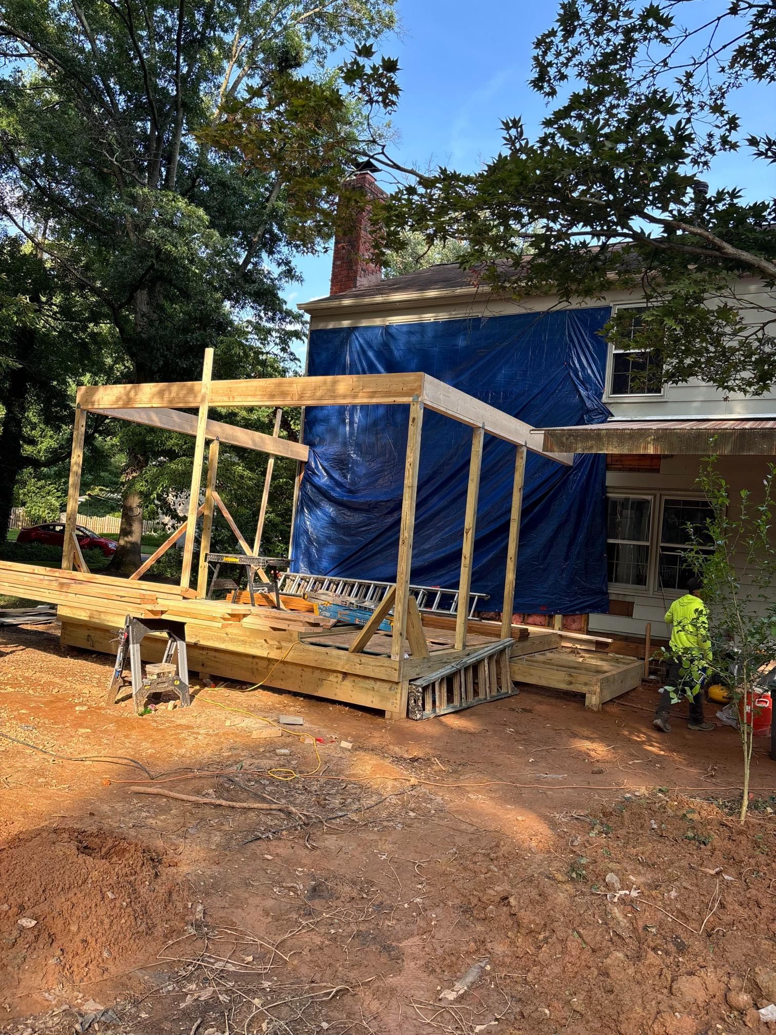A wooden deck is being built in front of a house.