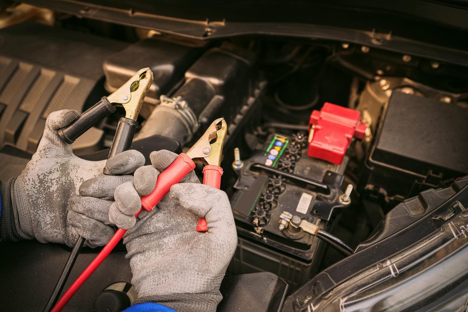A person is charging a car battery with a charger.