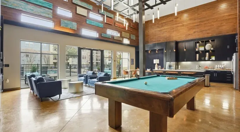 Spacious modern lounge with a billiards table, high ceilings, large windows, and seating area at Layers Galleria.