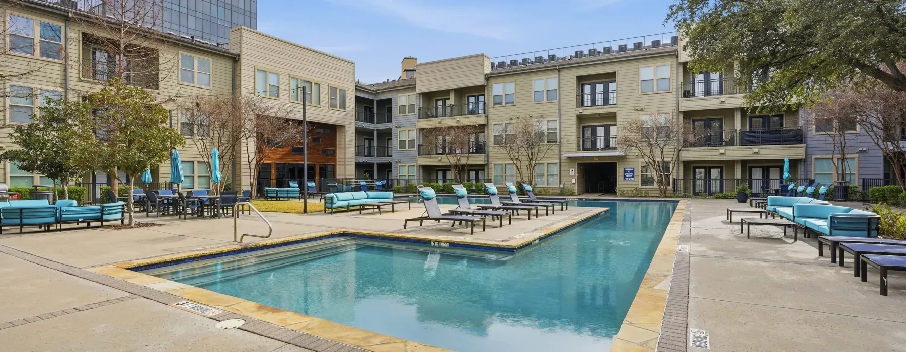 Apartment courtyard with a swimming pool, lounge chairs, and surrounding balconies at Layers Galleria.