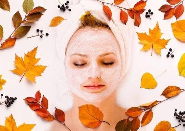 Woman receiving a facial mask treatment while lying on a spa bed