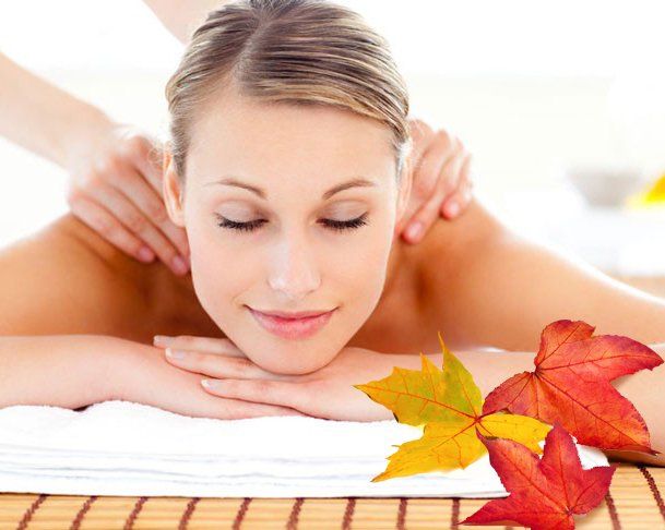 Relaxed woman receiving a shoulder massage with eyes closed on a spa table