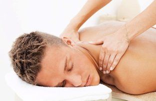 Person receiving a back and neck massage on a white spa table