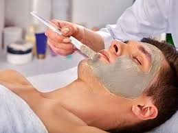 A person receives a facial mask treatment while lying back in a spa chair.