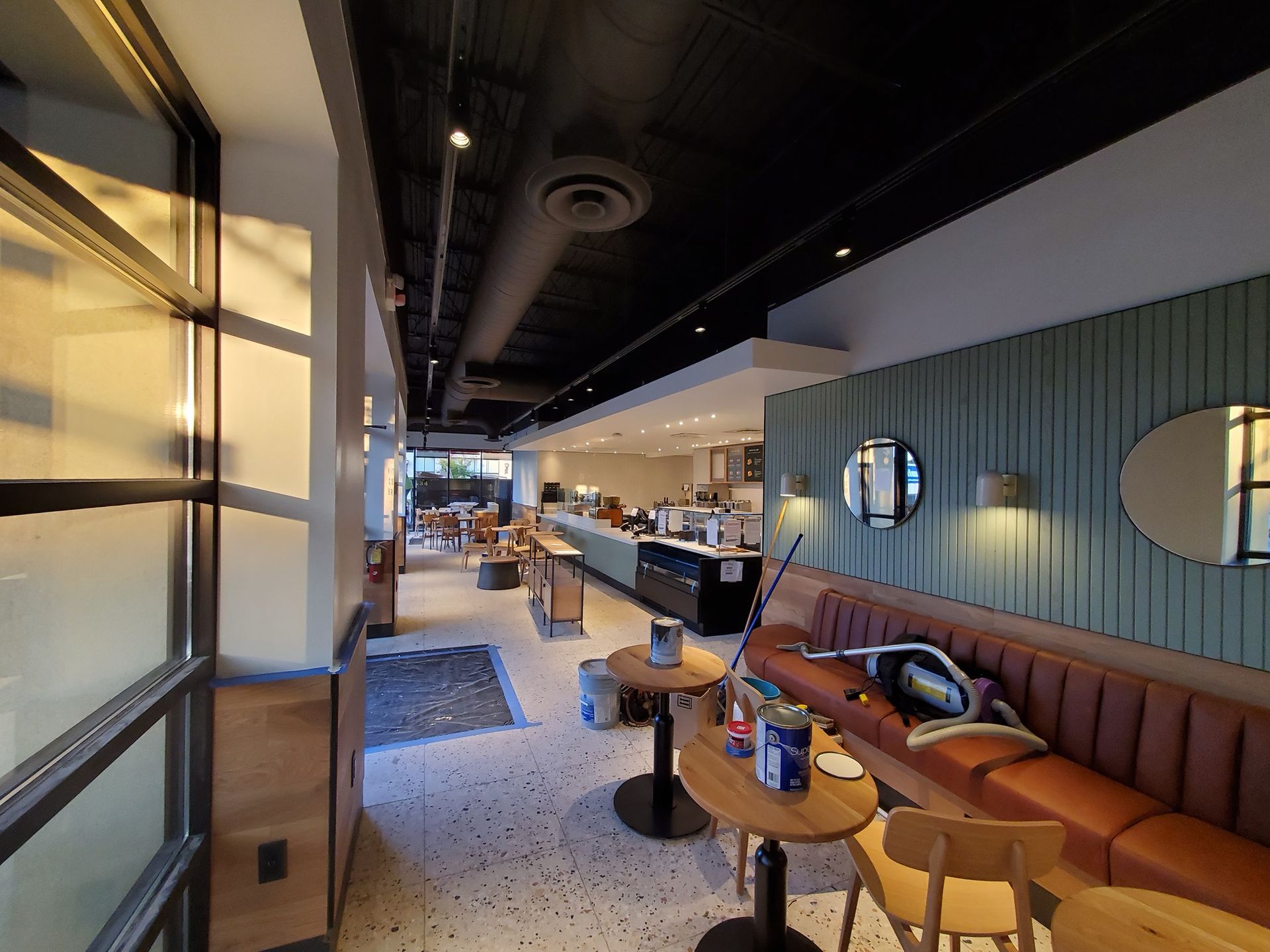 Interior of a cafe with seating, counter, and a window to the outside.