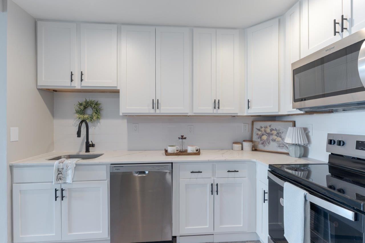 Bright white kitchen with stainless steel appliances and white cabinets