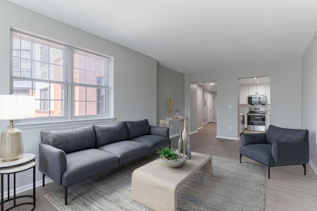 Bright living room with gray sofa, armchair, coffee table, and window light.