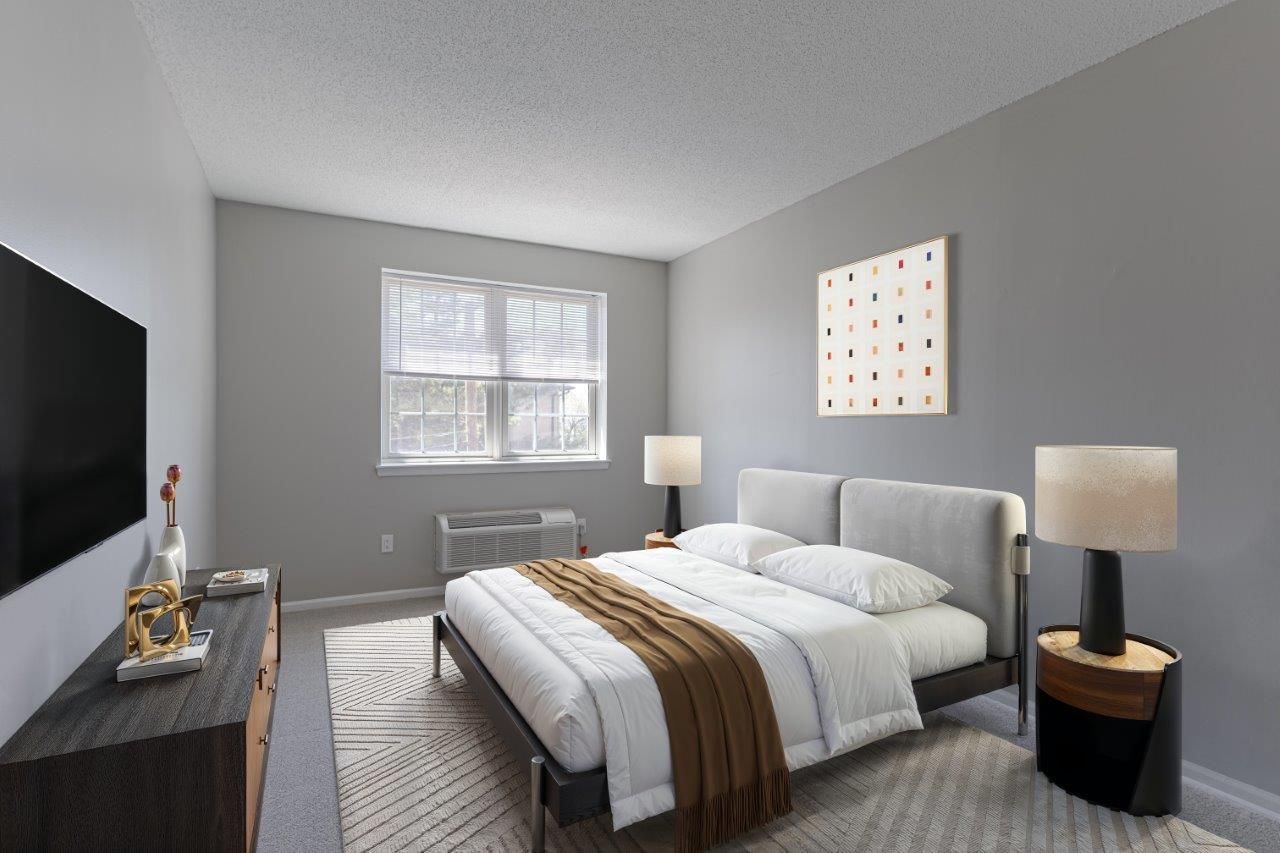 Modern gray bedroom with a bed, two lamps, dresser, TV, and a window with blinds.