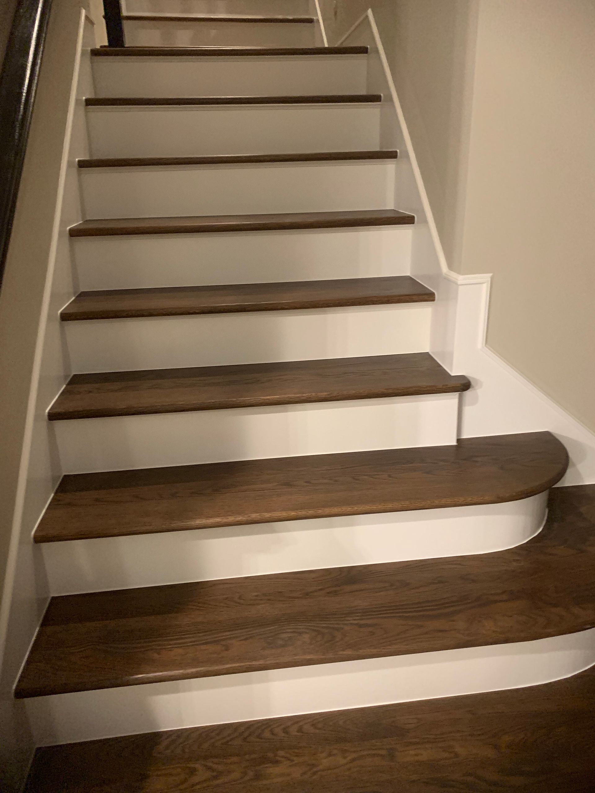 Wooden staircase with dark brown treads and white risers.