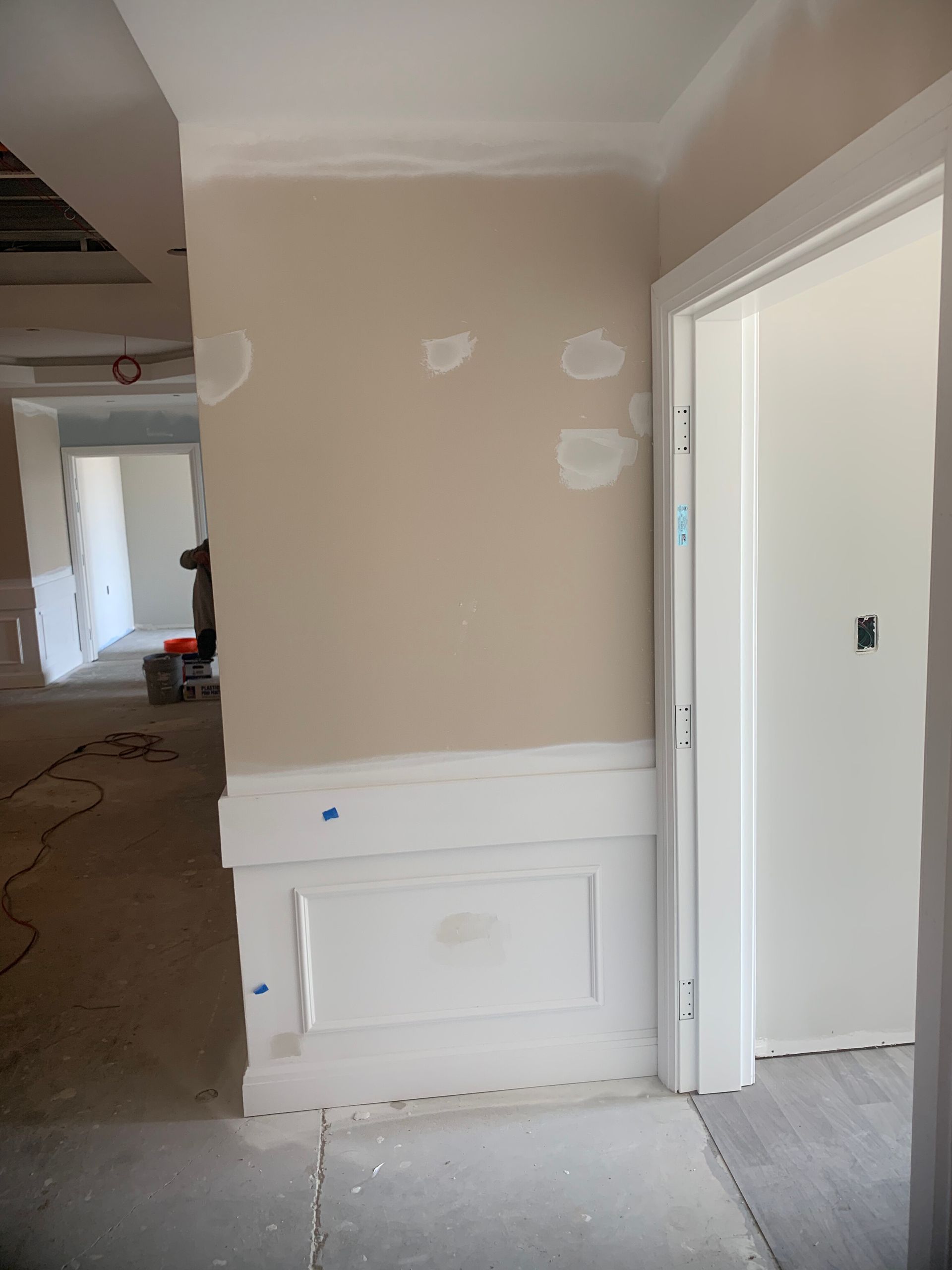 Interior room under construction, featuring light walls, white trim, and a doorway.