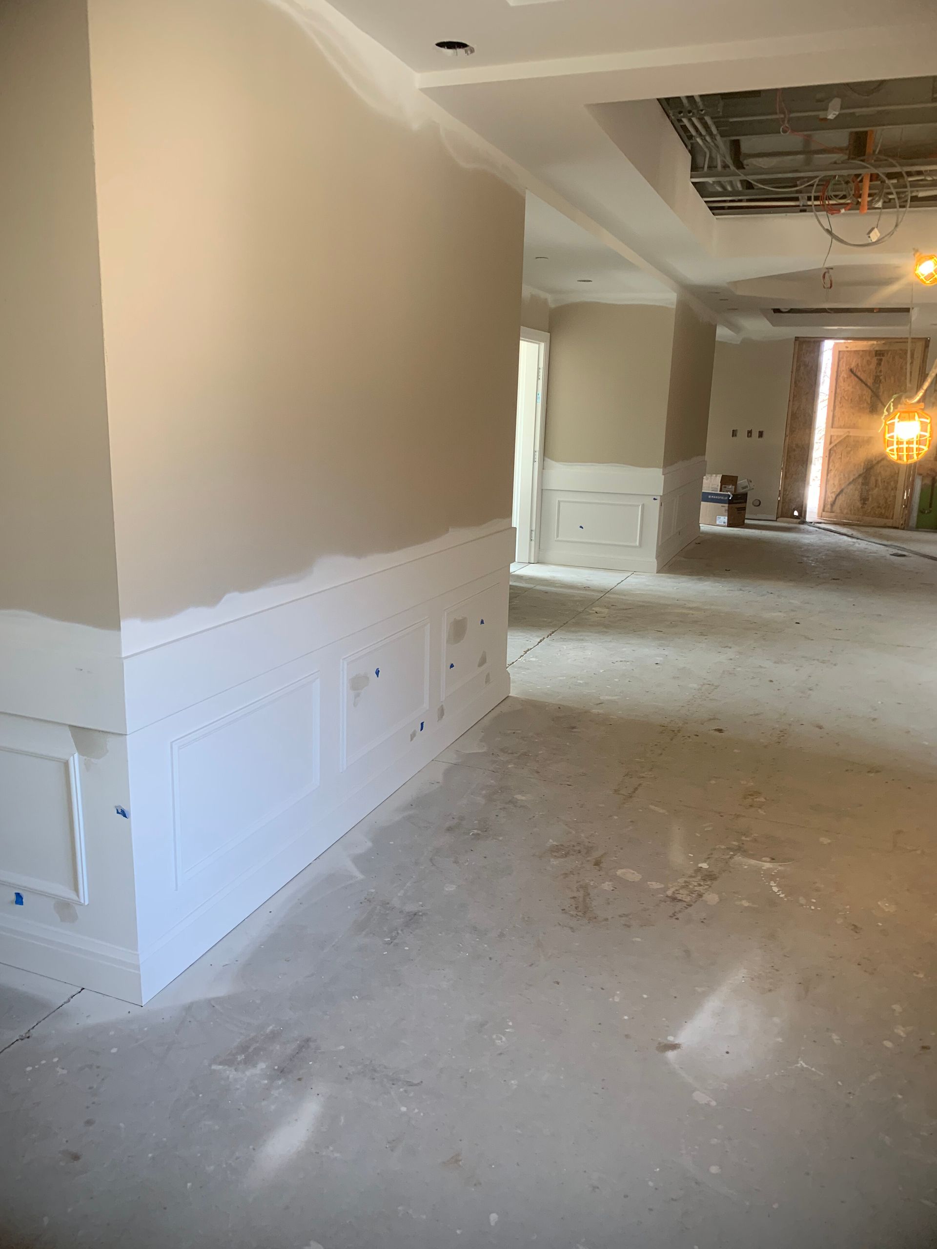 Interior construction: beige walls, white trim, concrete floor, open space.