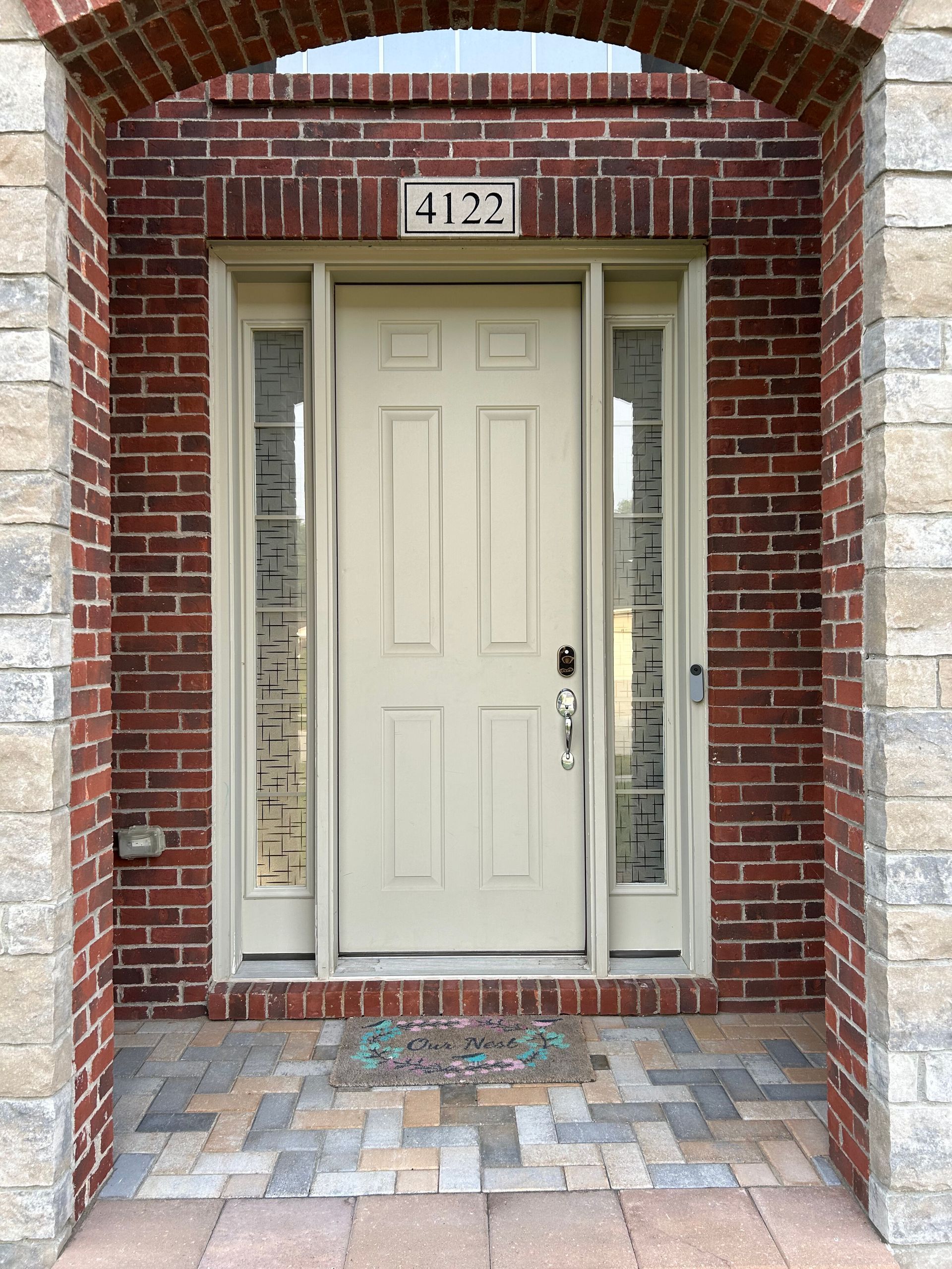 Beige front door with sidelights, brick and stone exterior, address 4123 above.