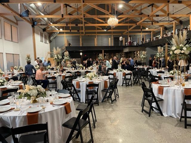 A large room with tables and chairs set up for a wedding reception.