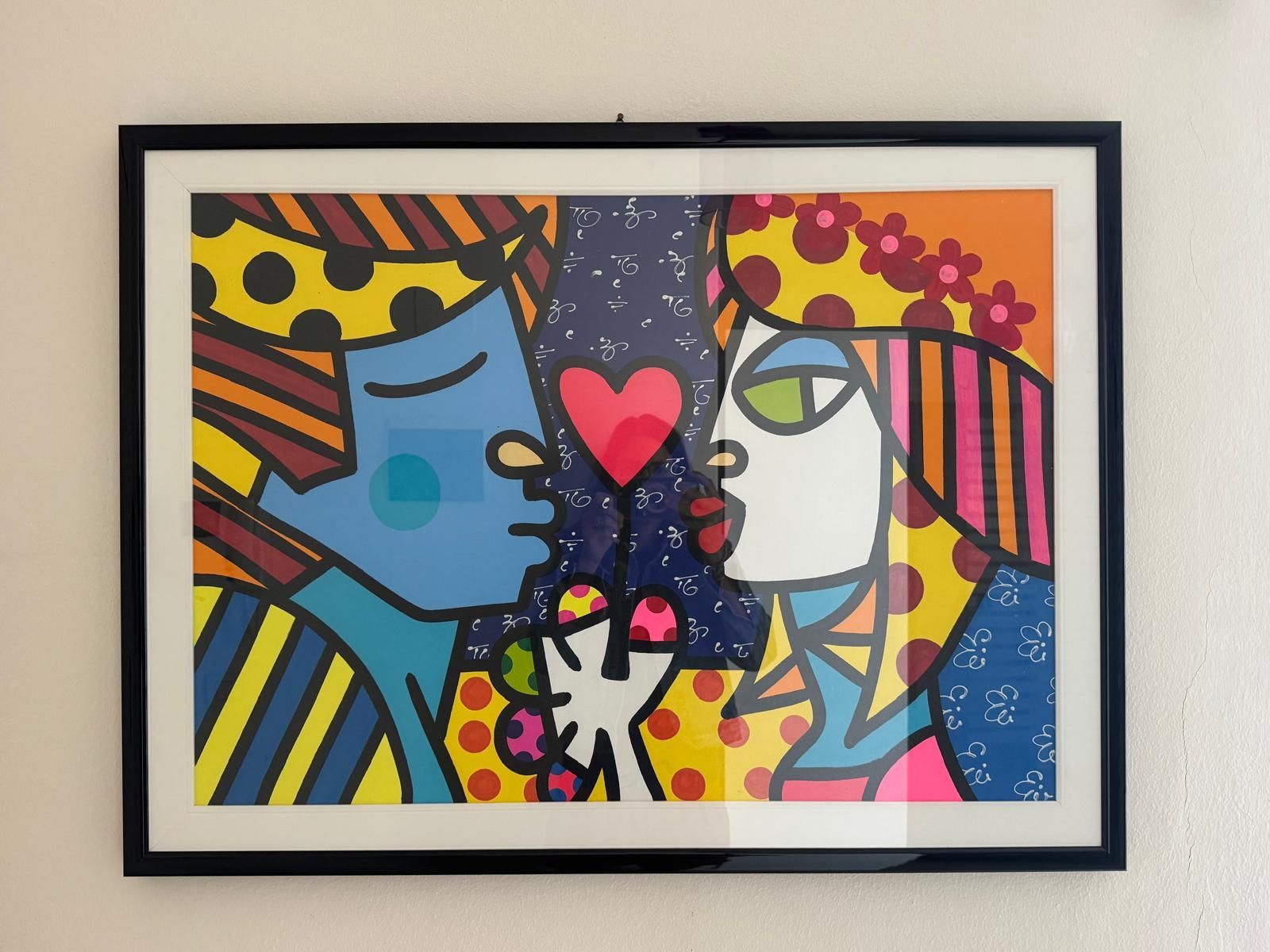 Dipinto pop art colorato con due volti di profilo e un cuore rosso tra loro, in una cornice nera