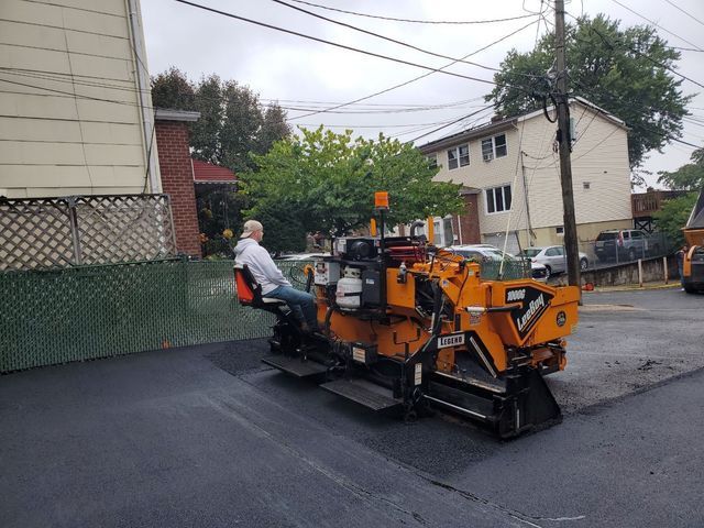 A man is sitting on a machine that has the word asphalt on it