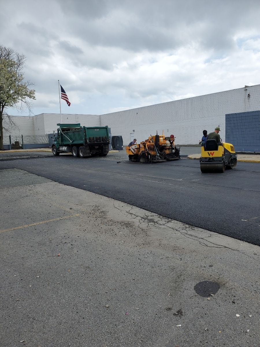 A dump truck is parked on the side of the road in front of a building.