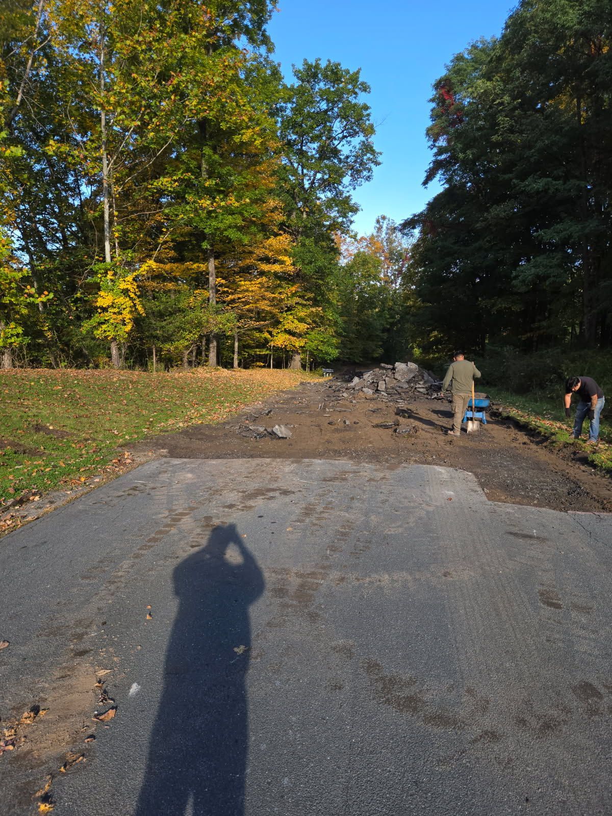 A man is driving a yellow roller on a road.