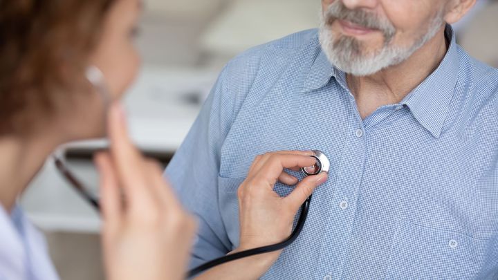 Doctor using a stethoscope to examine a patient's chest.