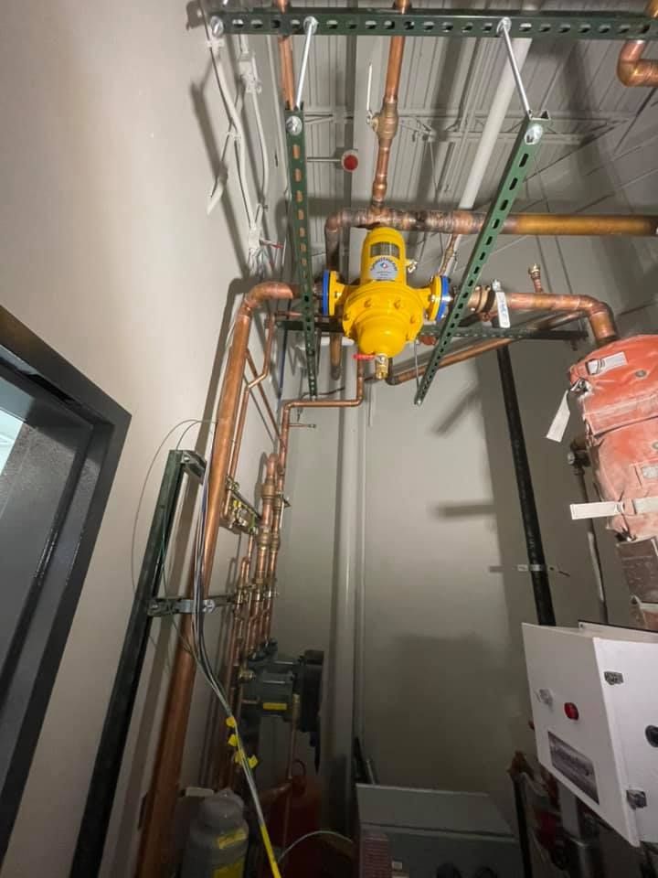 Industrial machinery and copper piping installed on a ceiling in a utility room