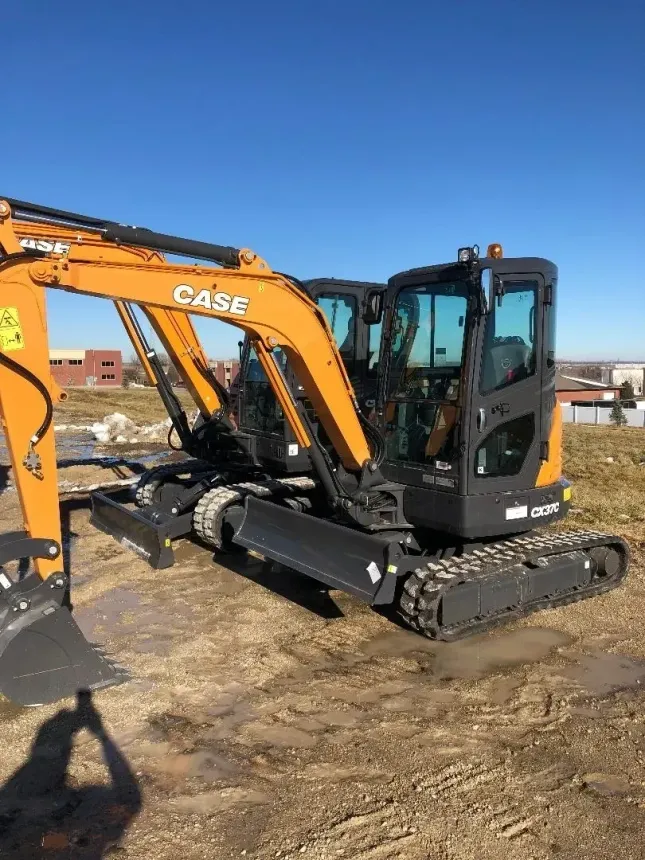Orange excavator on a construction site under a clear blue sky Orange excavator on a construction site under a clear blue sky