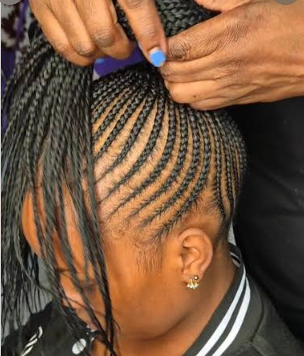 Close-up of braided hair styled in intricate, looping cornrows with dark and light brown strands