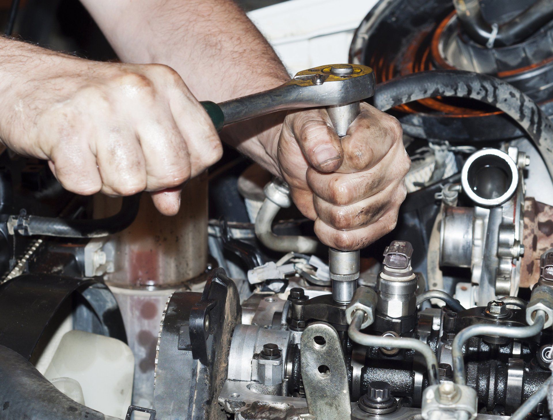 Mechanic using a wrench on an engine part during vehicle repair