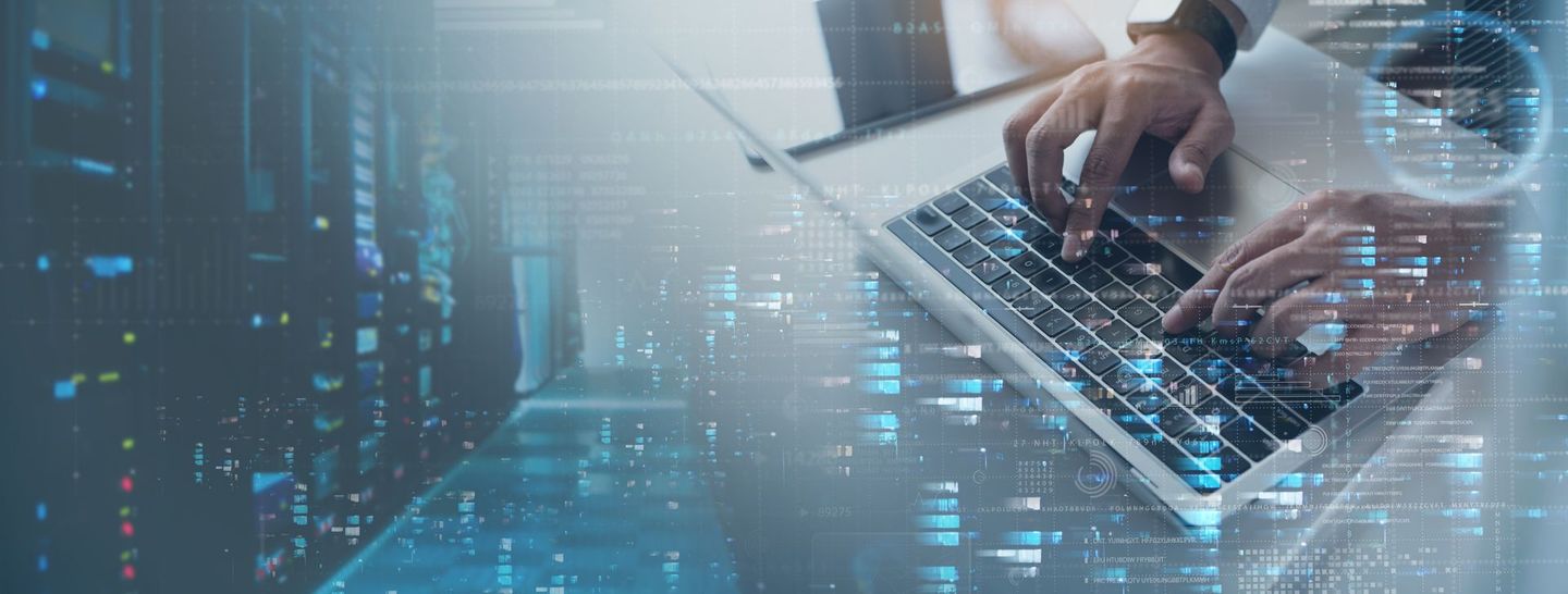 IT professional working on a laptop, surrounded by data and server visuals.