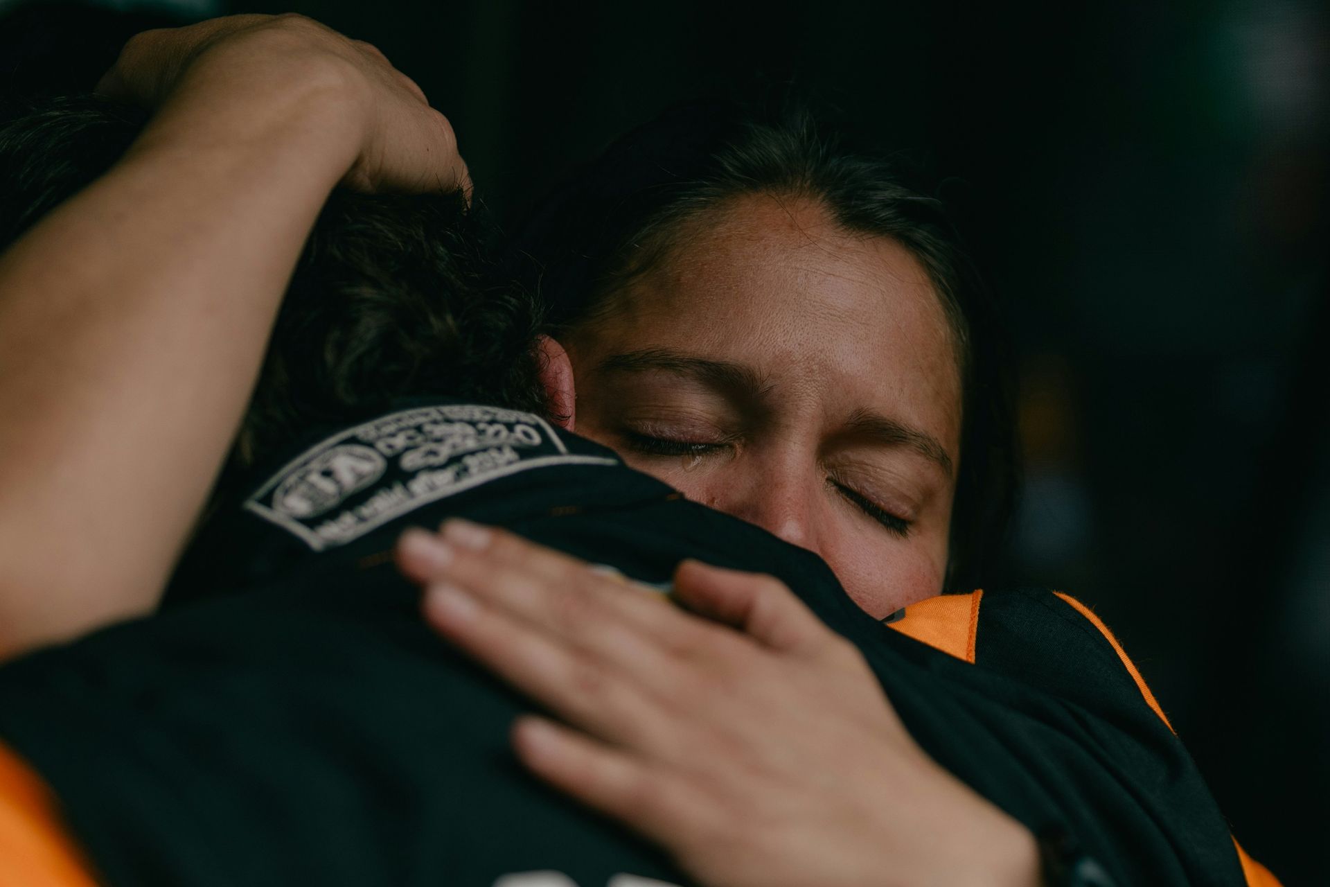 A woman is hugging a man with her eyes closed.