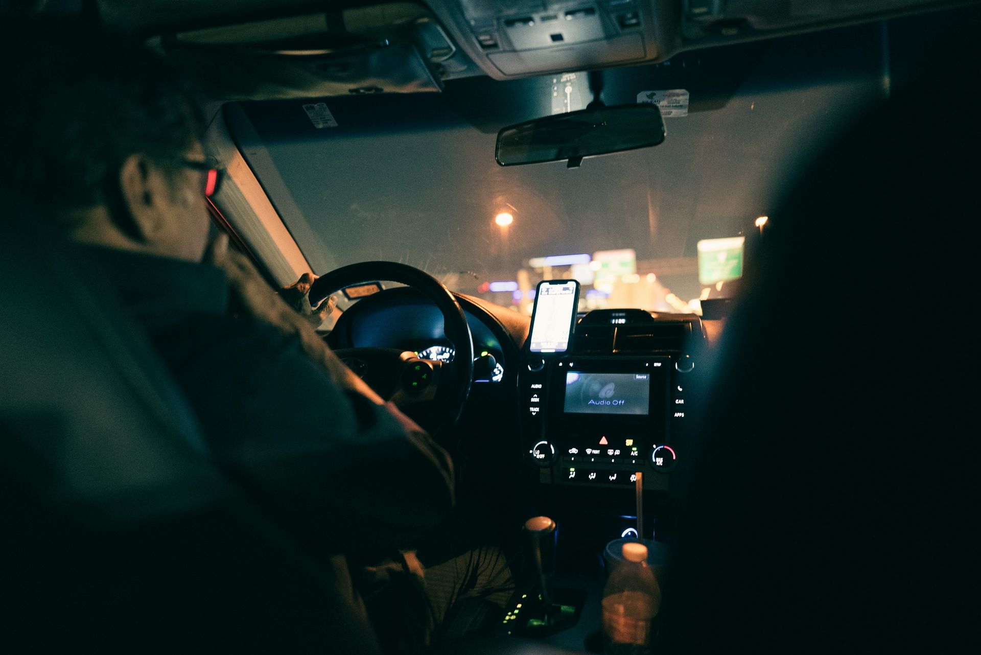 A man is driving a car at night.