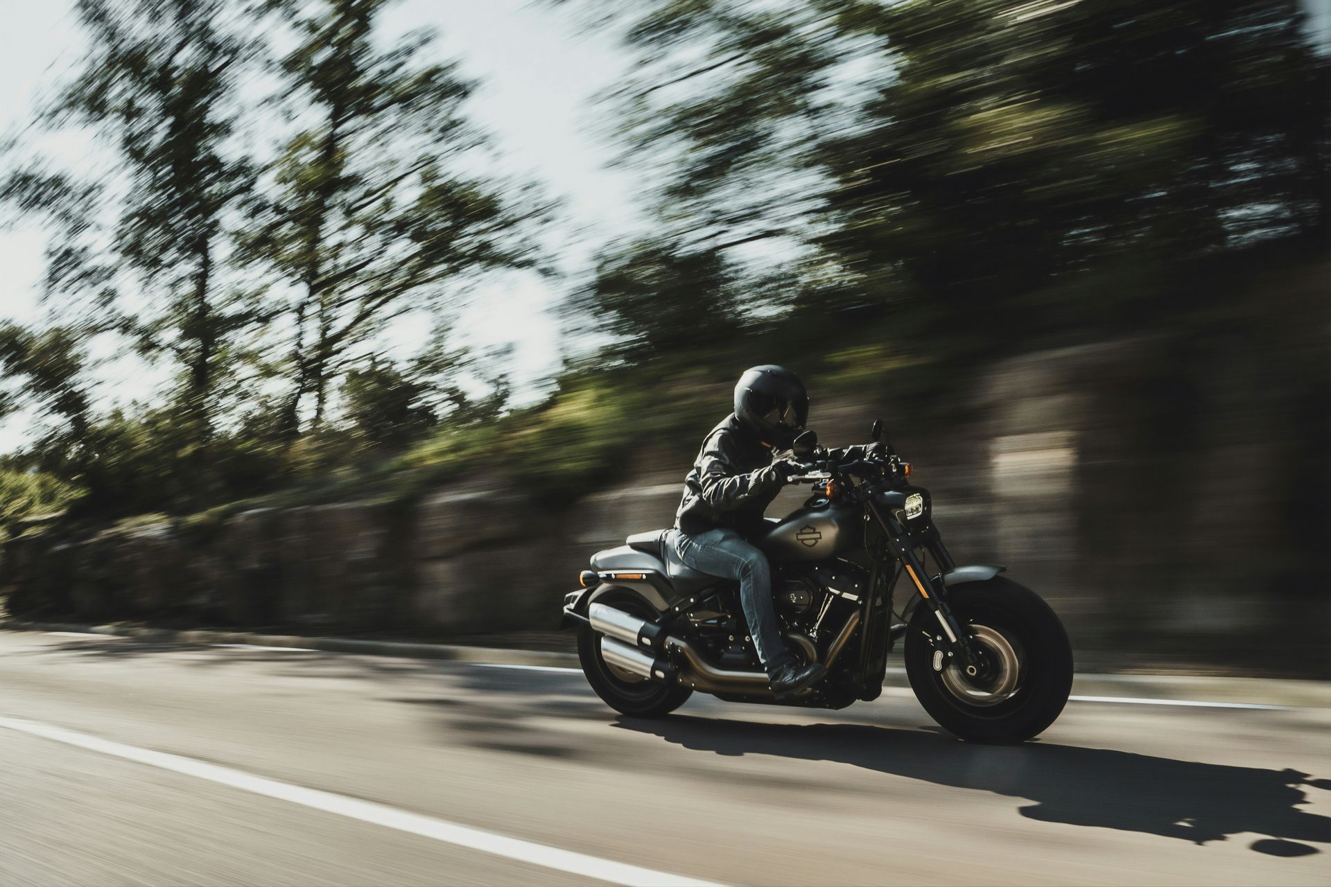 A man is riding a motorcycle down a road.