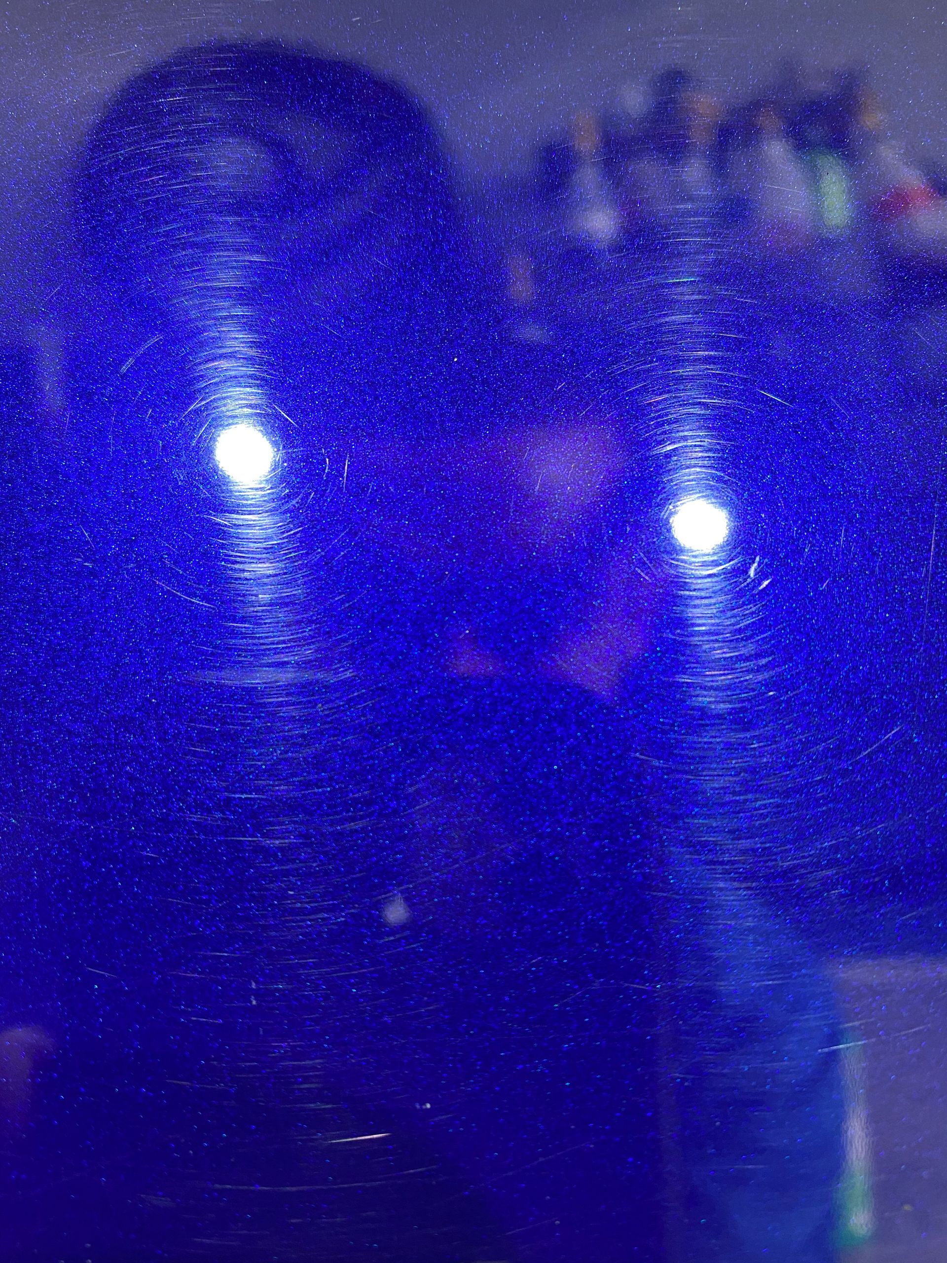 A person is taking a selfie in front of a blue background.