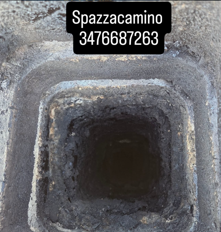 Primo piano dell'apertura scura e fuligginosa di un camino, con sovrapposizione del testo:
