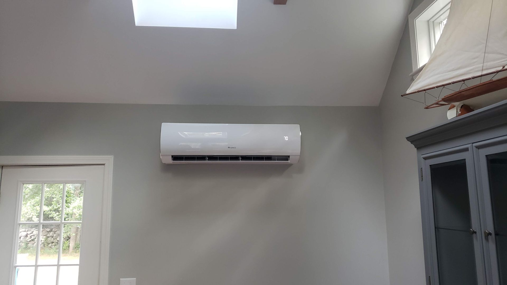 A room with a window and a fan on the wall.